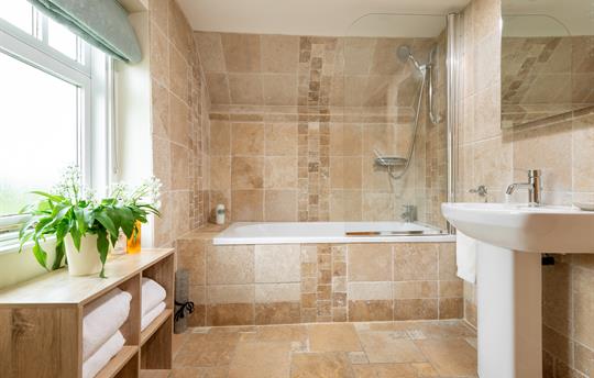 Stylish bathroom with shower over bath