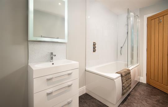 Family bathroom with LED-lit mirror