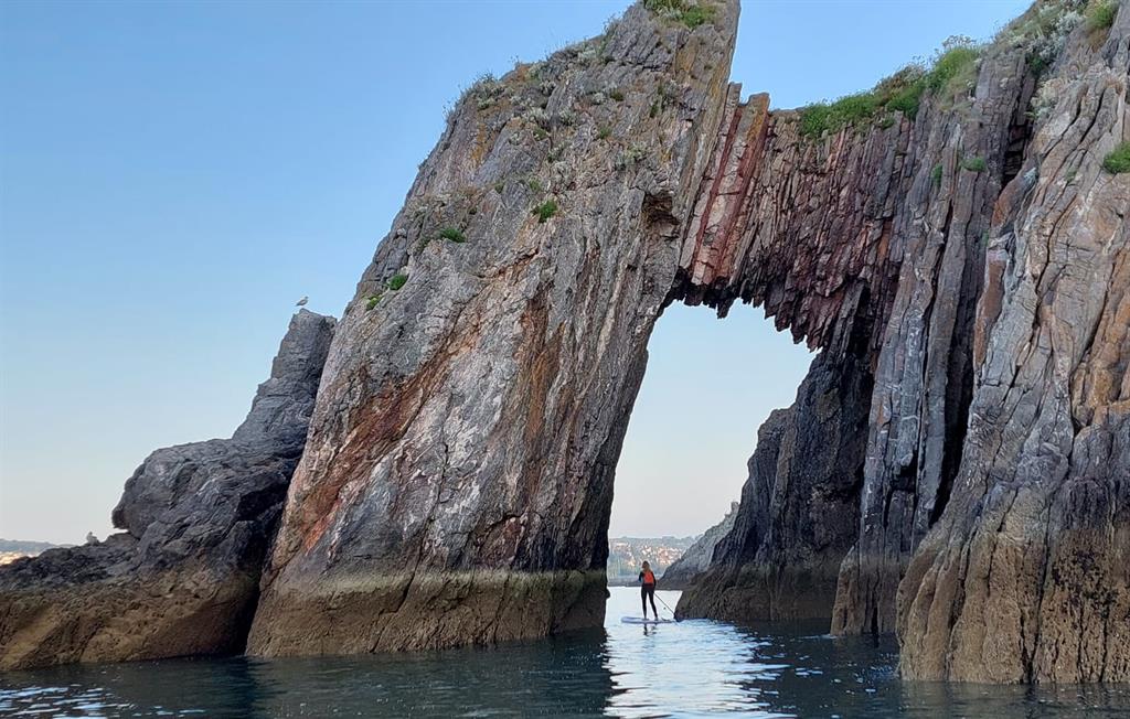 Paddleboard under Torquay's natural stone arch