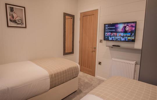 Smart TV and wardrobe in twin bedroom