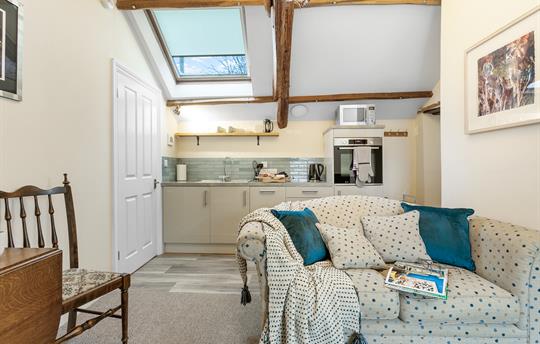 Open-plan lounge with exposed beams & comfy sofa