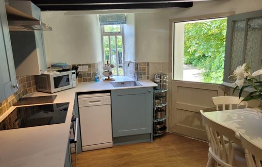 Kitchen with half open door in Round House