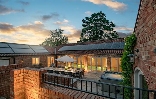 Evening photo of the hot tub, pool room and table