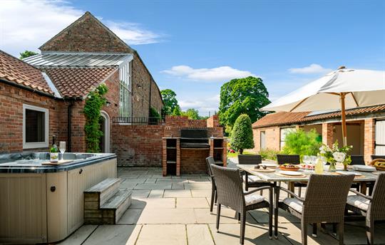 Outdoor area with dining table, hot tub and bbq