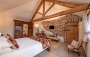The Old Barn bedroom with oak beams & exposed wall