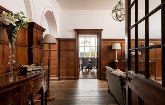 Oak panelled hallway view into dining room
