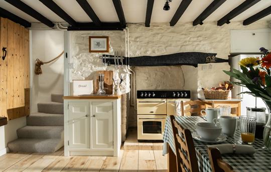 Country kitchen withs original stair case 