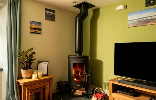 Coach House logburner and TV in the living room