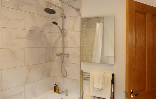 Bath with overhead shower in private bathroom