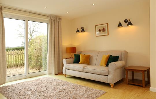 Spacious sitting room with doors leading to patio