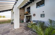 Patio area with glass roof. Sofa and dining table.