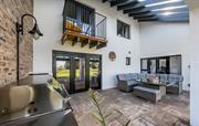 Bi-fold doors open onto patio with BBQ & dining