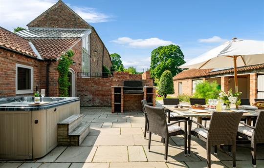 Outdoor area with dining table, hot tub and bbq