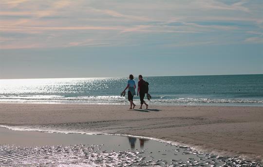 Couple walking barefoot on the beach