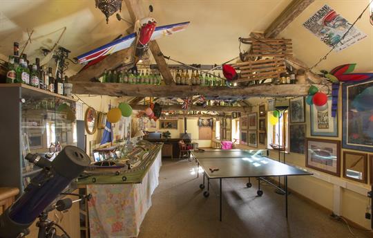 Games room full of character with huge log burner 